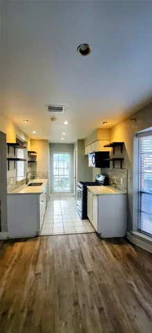 a large kitchen with stainless steel appliances a large counter top