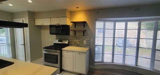 a kitchen with a sink a refrigerator and cabinets