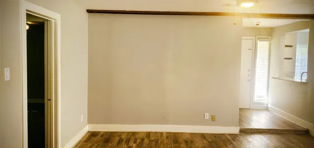 a view of a room with wooden floor and a window