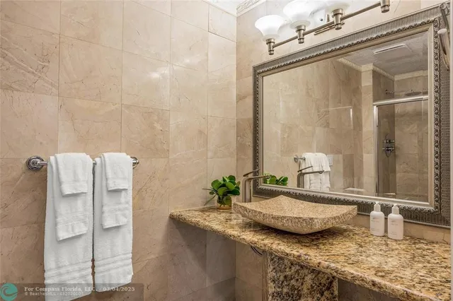 a bathroom with a granite countertop shower and a sink