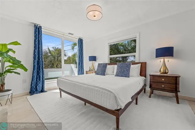 a bedroom with a bed a fireplace and a potted plant