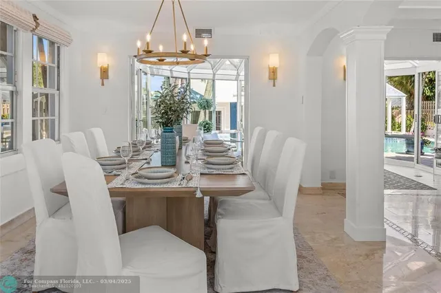 a dining room with furniture a chandelier and wooden floor