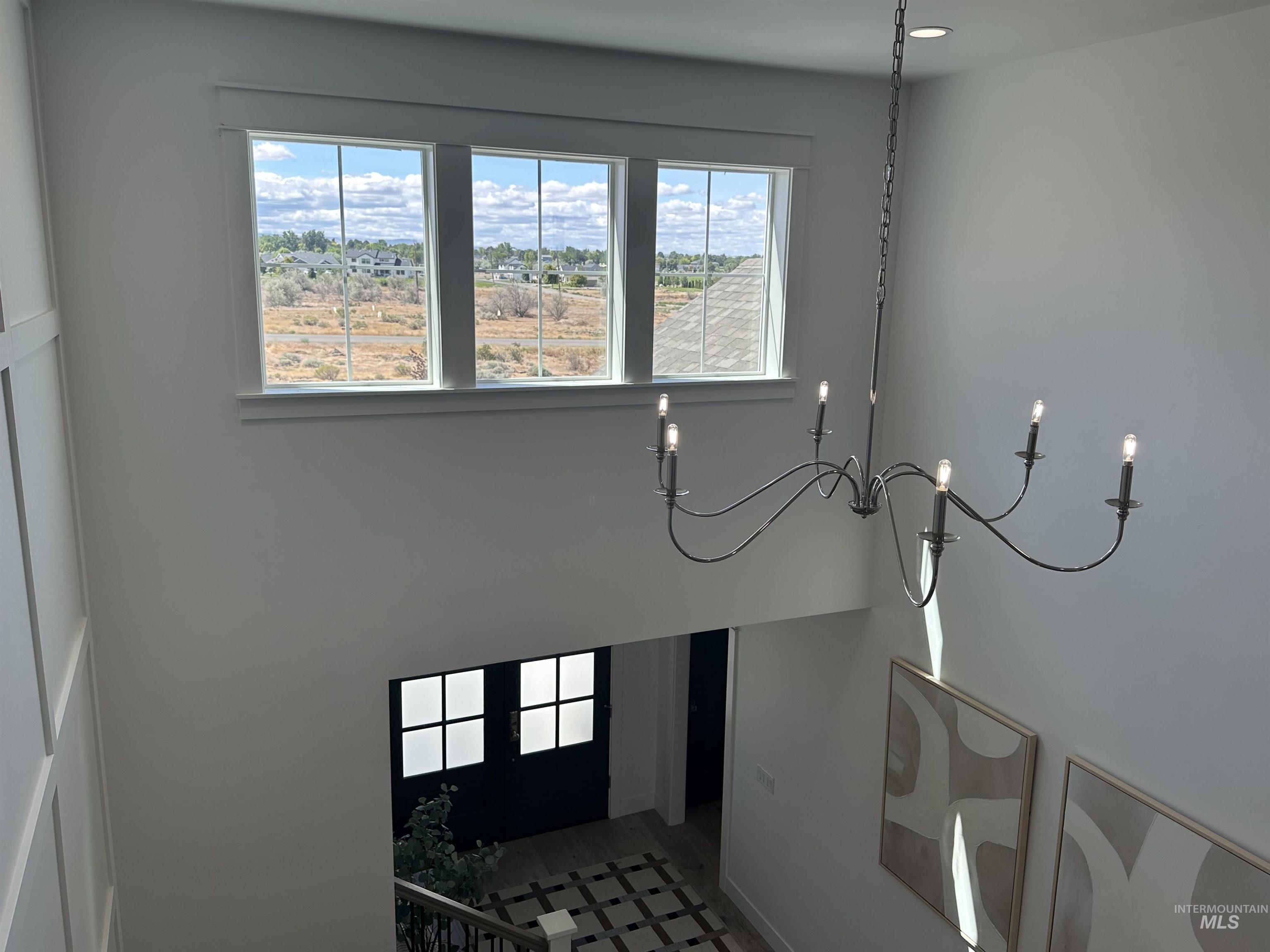 3035 Lake View Twin Falls, ID 83301 - Photo 37 of 41 Grand entryway featuring an elegant chandelier, high ceilings, large transom windows, and a dark-paneled door