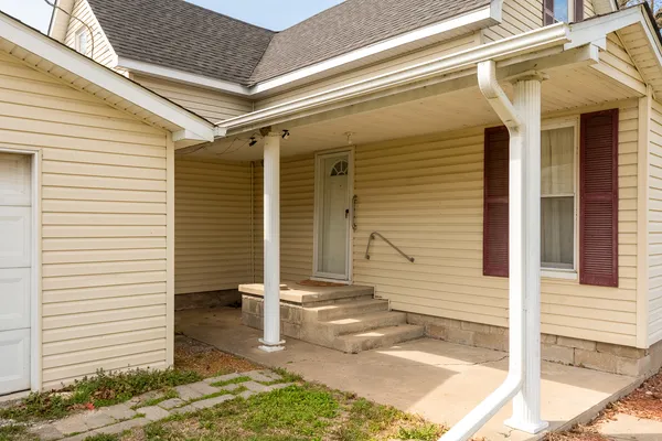 a view of a porch with a door and wooden floor