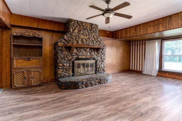 a view of an empty room with a fireplace and a window