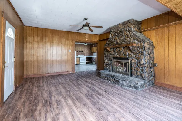 a view of a livingroom with wooden floor fireplace and a window