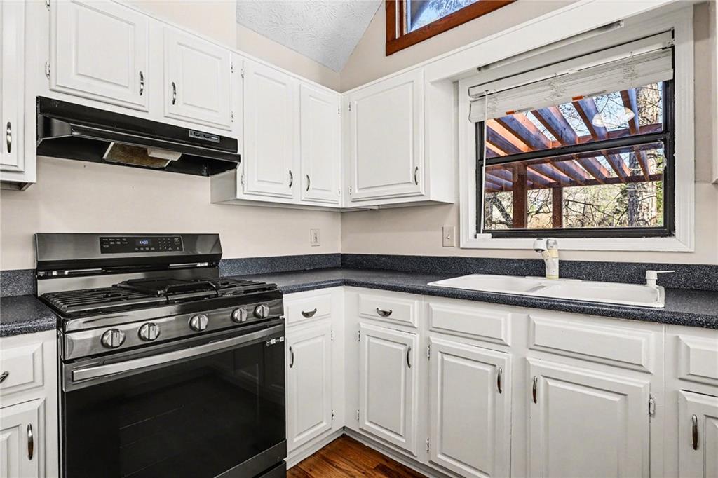 2711 Old Coach Road Duluth, GA 30096 - Photo 10 of 33 a kitchen with stainless steel appliances granite countertop white cabinets and a stove top oven