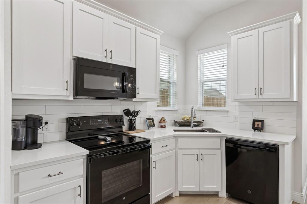388 Montague Street Pilot Point, TX 76258 - Photo 12 of 28 a kitchen with stainless steel appliances white cabinets granite counter tops and a window