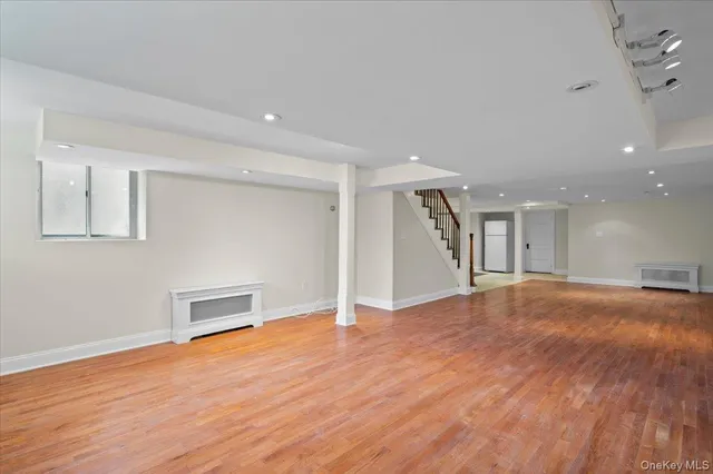 a view of empty room with wooden floor and fireplace
