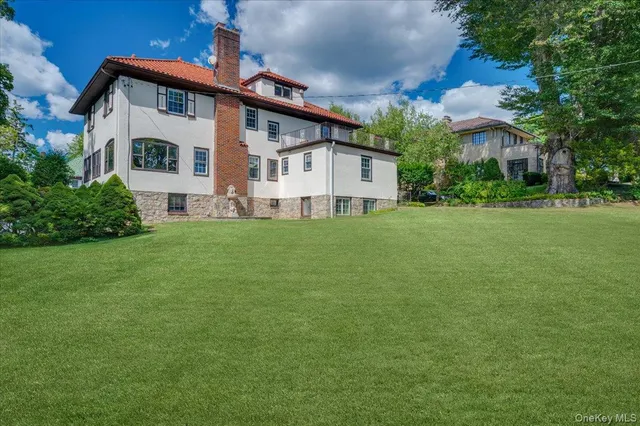 a view of a house with a big yard and large trees