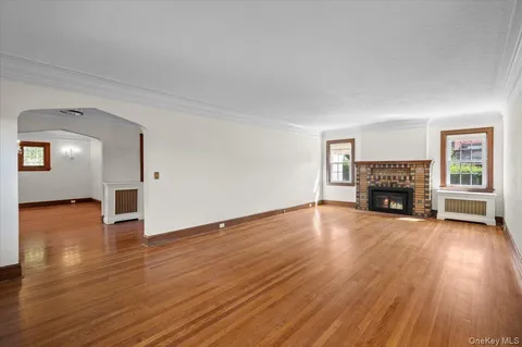 a view of empty room with fireplace and wooden floor