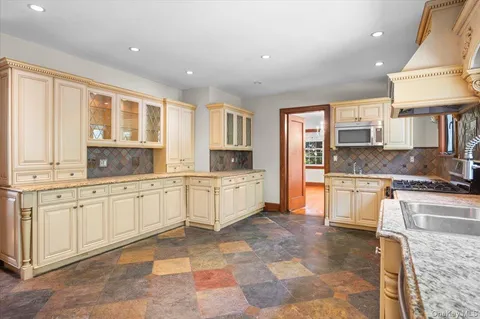 a large kitchen with stainless steel appliances granite countertop a stove and a sink