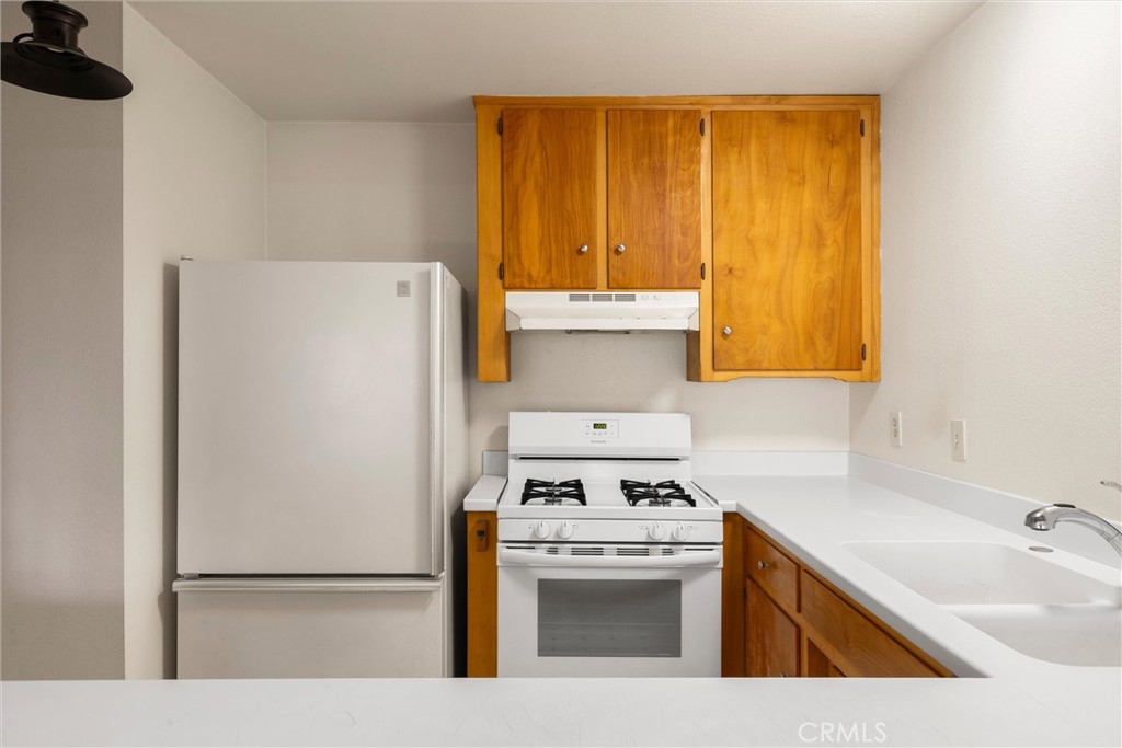 239 F Surf Street Morro Bay, CA 93442 - Photo 10 of 25 a kitchen with a refrigerator sink and cabinets