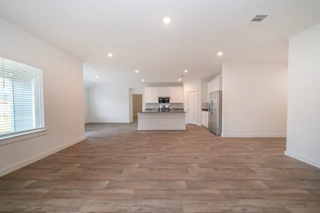 a view of large kitchen with a refrigerator and a window