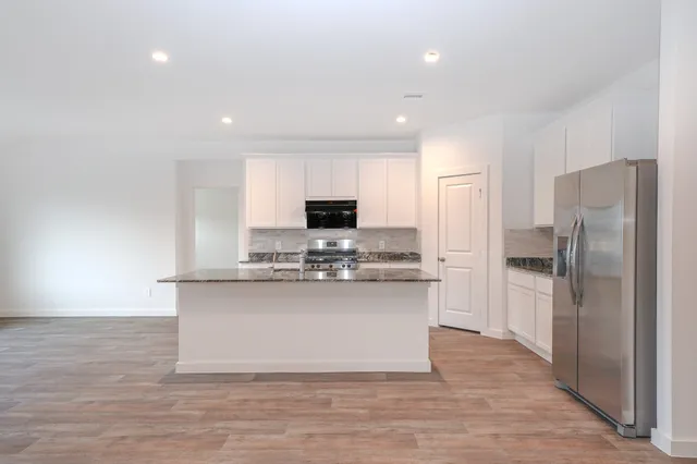 a kitchen with stainless steel appliances a refrigerator and a stove top oven