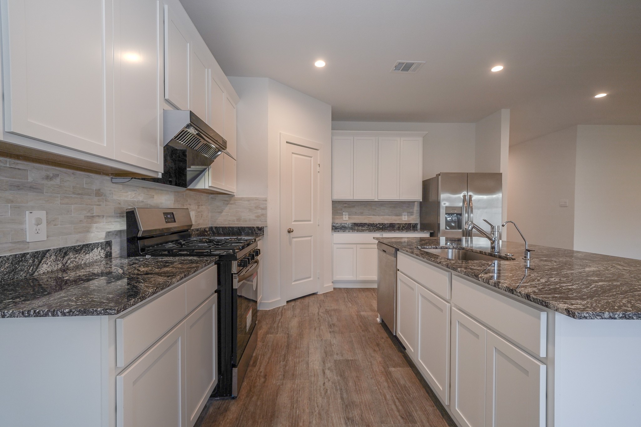 4526 Waving Willow Way Rosenberg, TX 77469 - Photo 21 of 40 a kitchen with stainless steel appliances granite countertop a sink stove and cabinets
