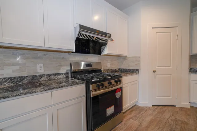 a kitchen with stainless steel appliances granite countertop a stove and a microwave