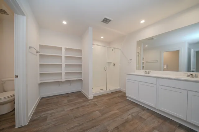 a bathroom with a sink a toilet and a large mirror