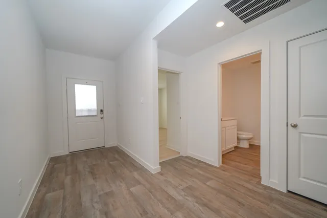an empty room with wooden floor and a window