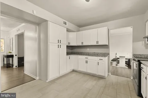 a kitchen with granite countertop white cabinets and stainless steel appliances