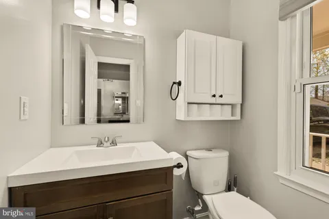 a bathroom with a sink vanity and toilet