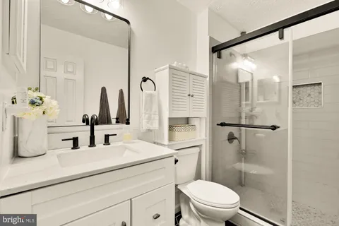 a bathroom with a double vanity sink toilet and shower