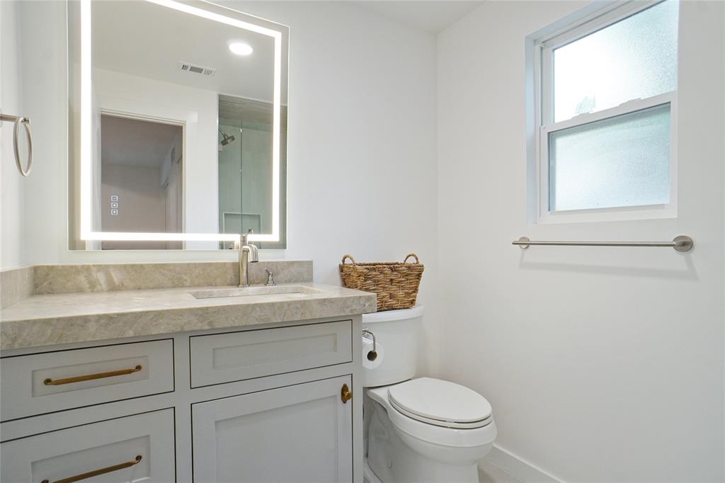 2147 Chaparral Gainesville, TX 76240 - Photo 17 of 40 a bathroom with a granite countertop toilet sink and mirror