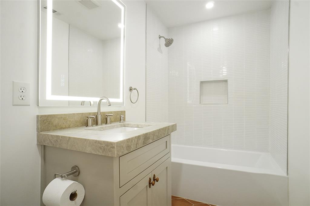 2147 Chaparral Gainesville, TX 76240 - Photo 29 of 40 a bathroom with a sink vanity tub shower and a mirror