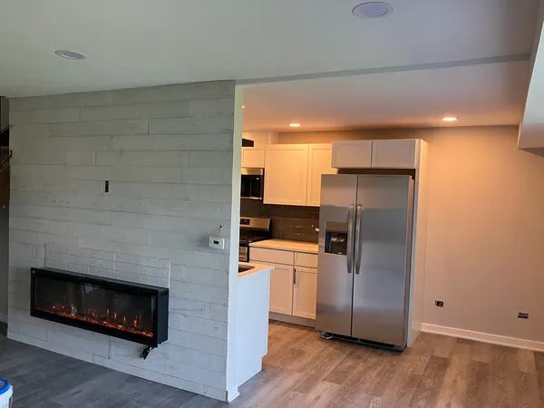 a kitchen with a refrigerator and a stove top oven