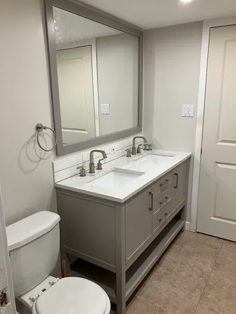 a bathroom with a toilet sink and mirror