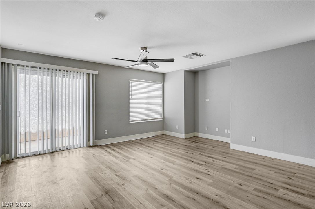 7259 Cestrum Road Las Vegas, NV 89113 - Photo 6 of 35 A spacious living area with resilient flooring offers a welcoming atmosphere and direct outdoor access.