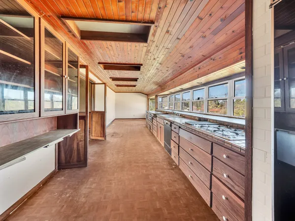 a large kitchen with stainless steel appliances granite countertop a large stove and a sink with cabinets