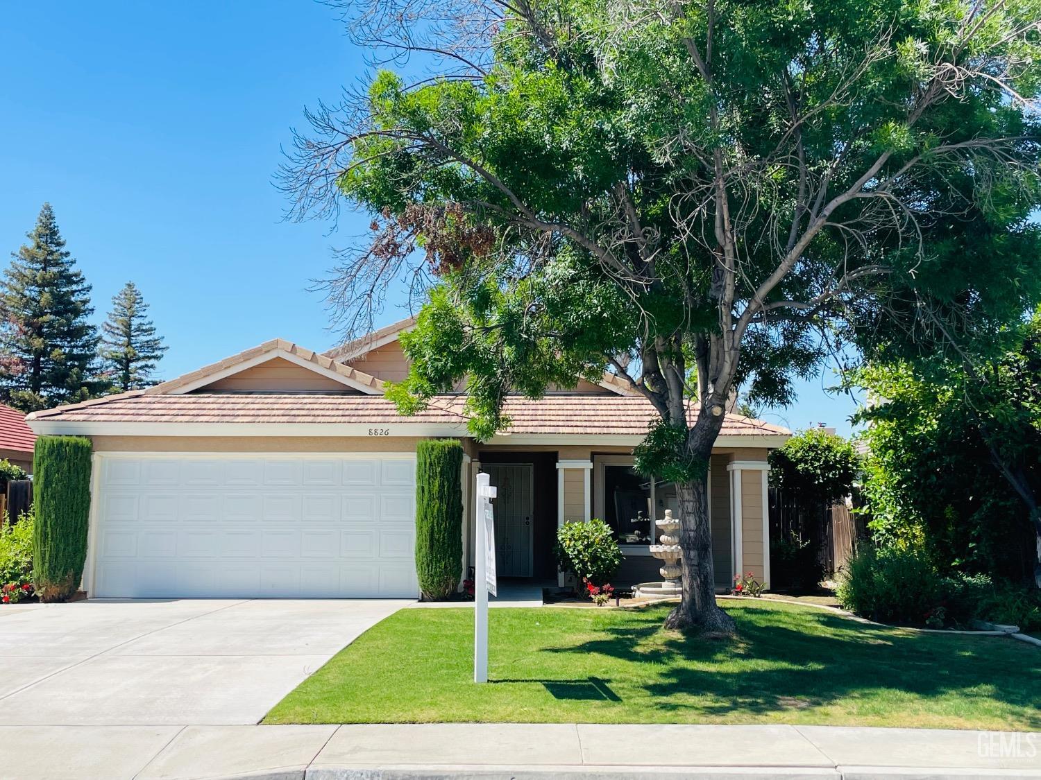 a front view of a house with a yard and trees