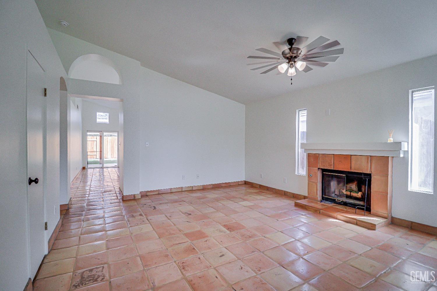 Undisclosed Address Bakersfield, CA 93312 - Photo 3 of 24 a view of an empty room with chandelier fan and fire place