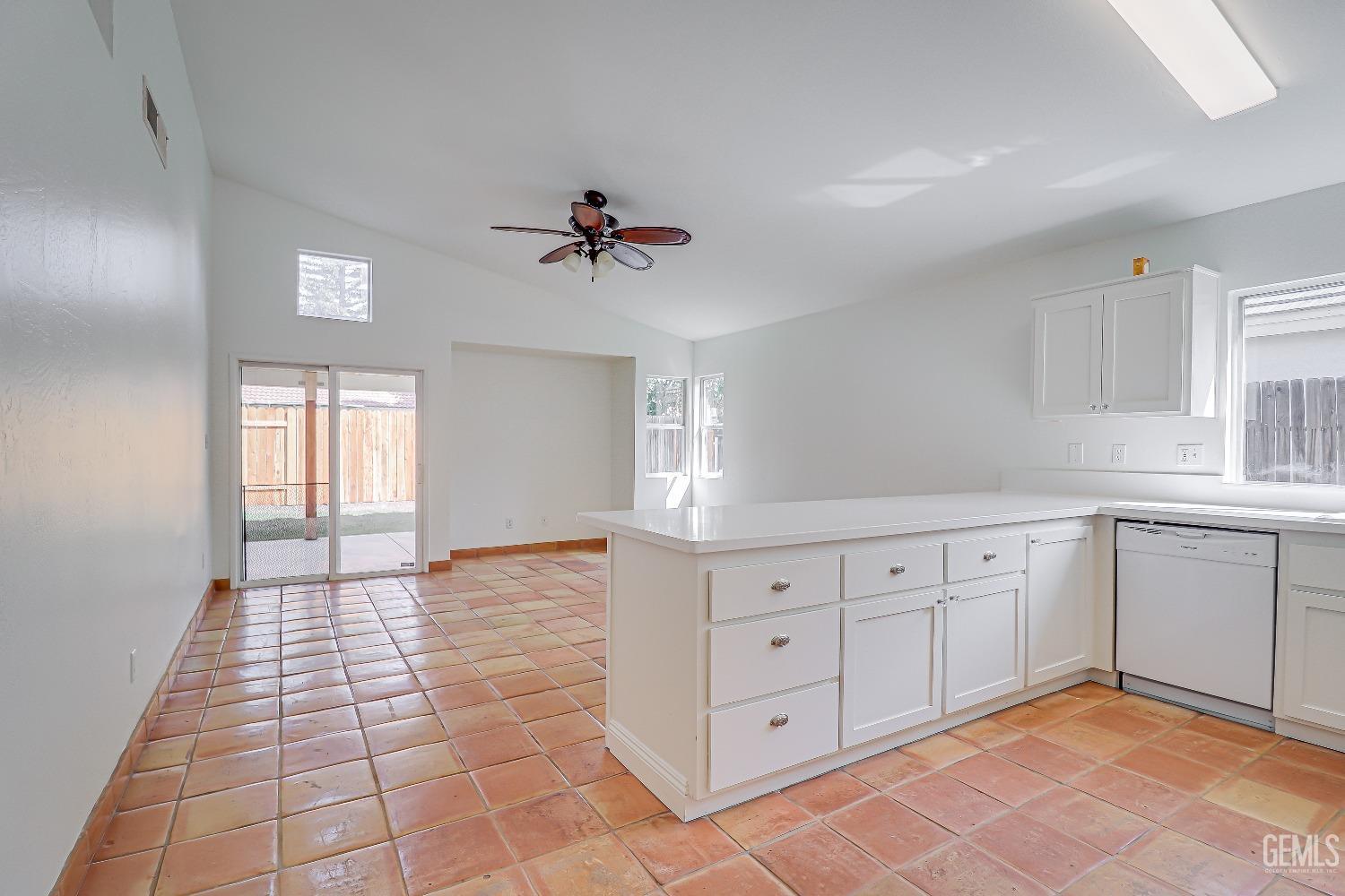 Undisclosed Address Bakersfield, CA 93312 - Photo 6 of 24 a large white kitchen with a white cabinets and chandelier