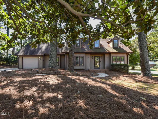 a view of a yard in front of a house with large tree