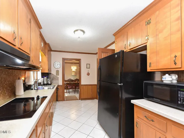 a kitchen with granite countertop a refrigerator and a sink