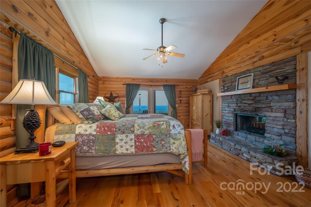 175 Big Rock Road Bostic, NC 28018 - Photo 26 of 45 a bedroom with a bed a ceiling fan and a fireplace