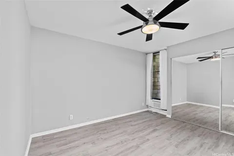 an empty room with closet and a ceiling fan