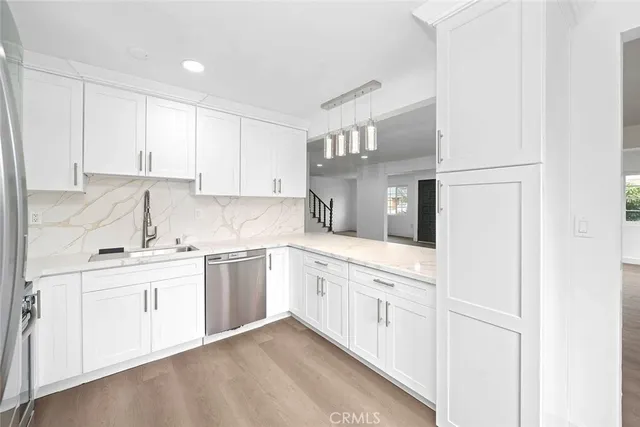 a kitchen with granite countertop white cabinets and white appliances
