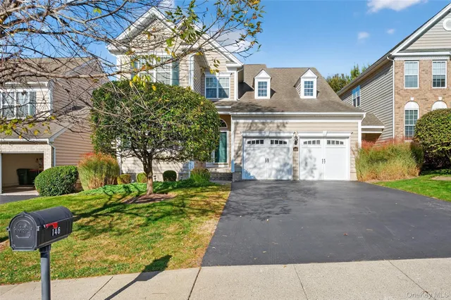 a front view of a house with a yard and garage