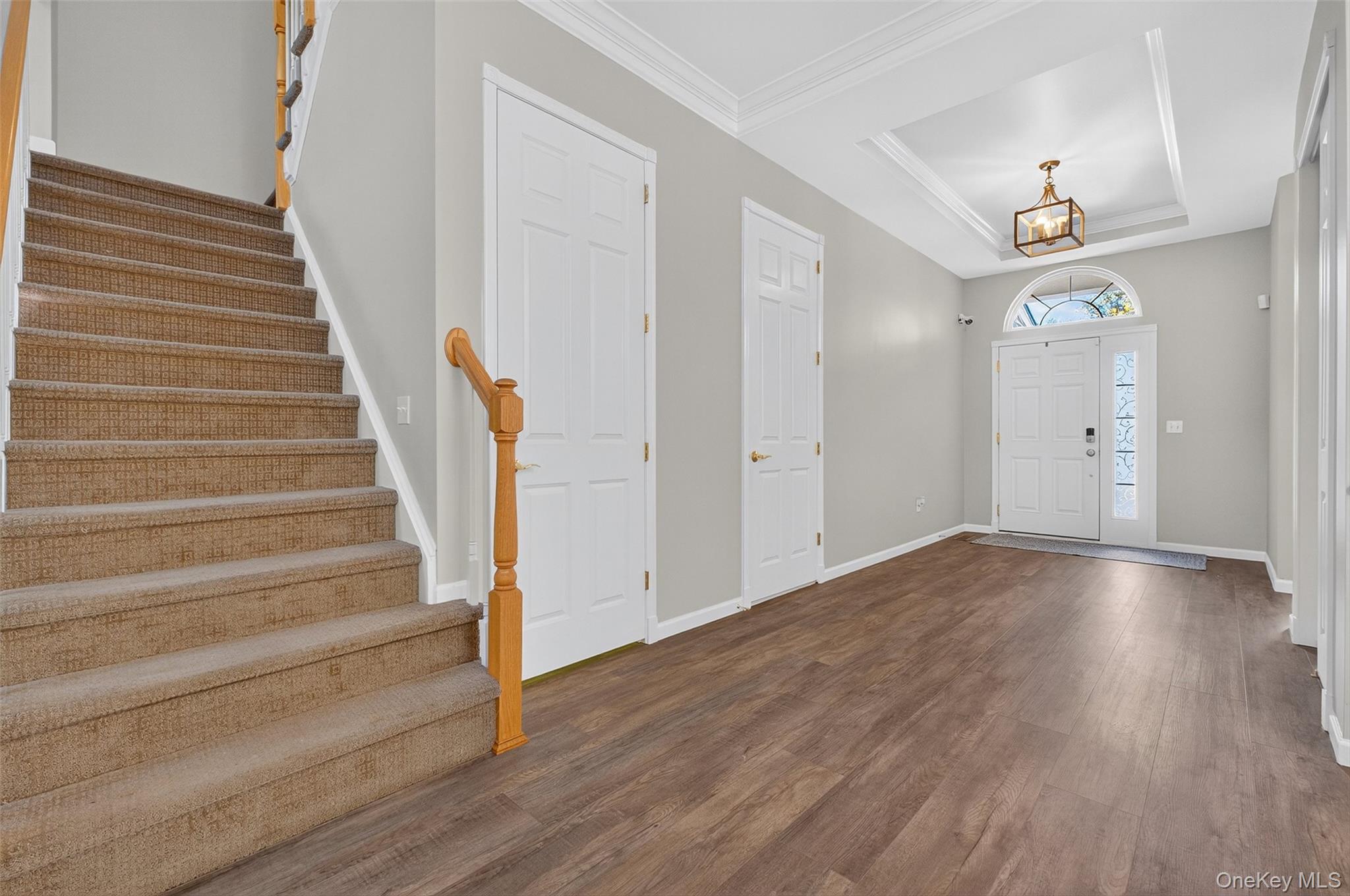146 Stony Brook Road Fishkill, NY 12524 - Photo 2 of 12 Foyer with a raised ceiling, dark wood-type flooring, stairs, and crown molding