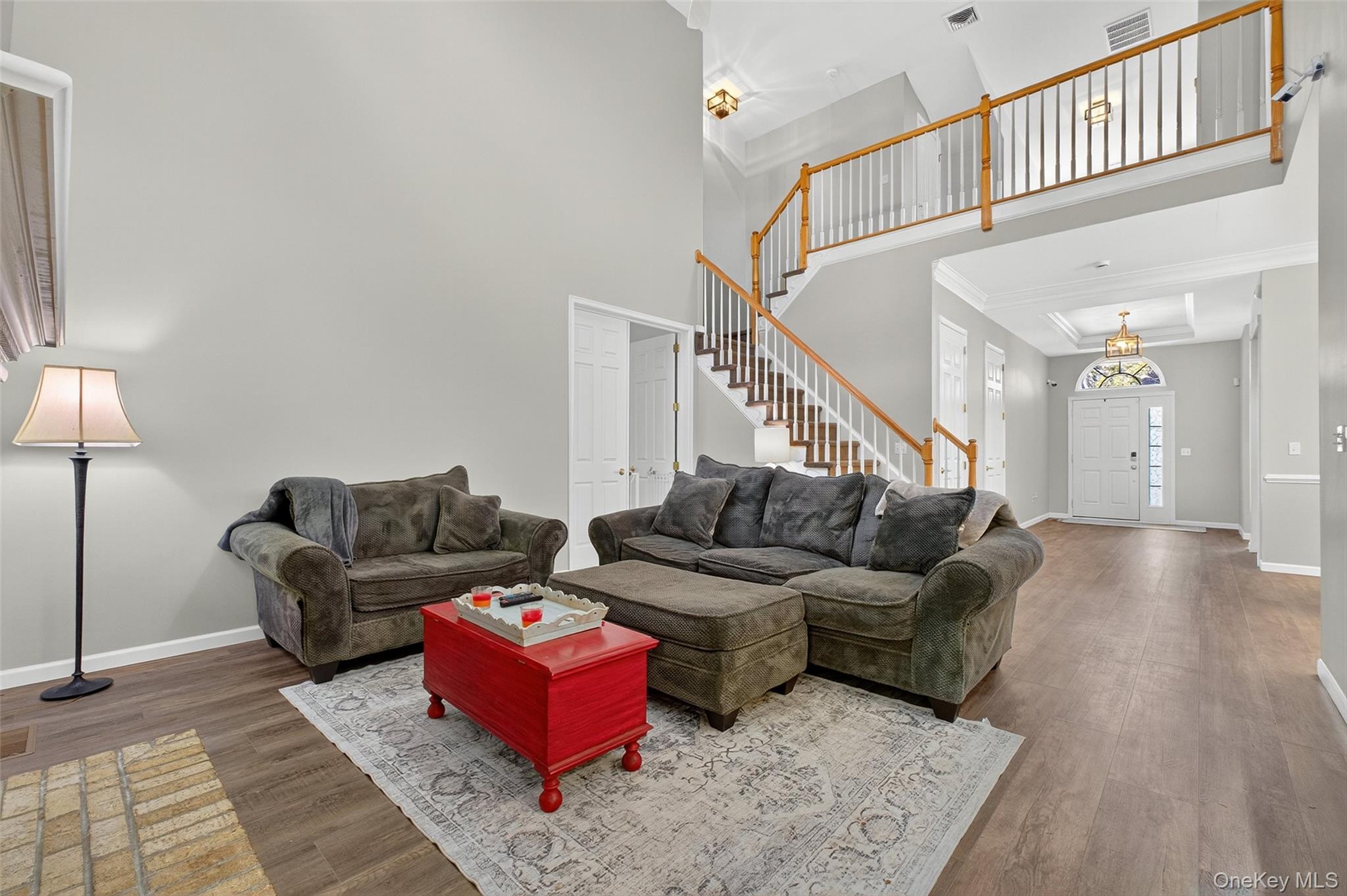 146 Stony Brook Road Fishkill, NY 12524 - Photo 4 of 12 Living area featuring dark wood-style floors, a high ceiling, crown molding, and stairs
