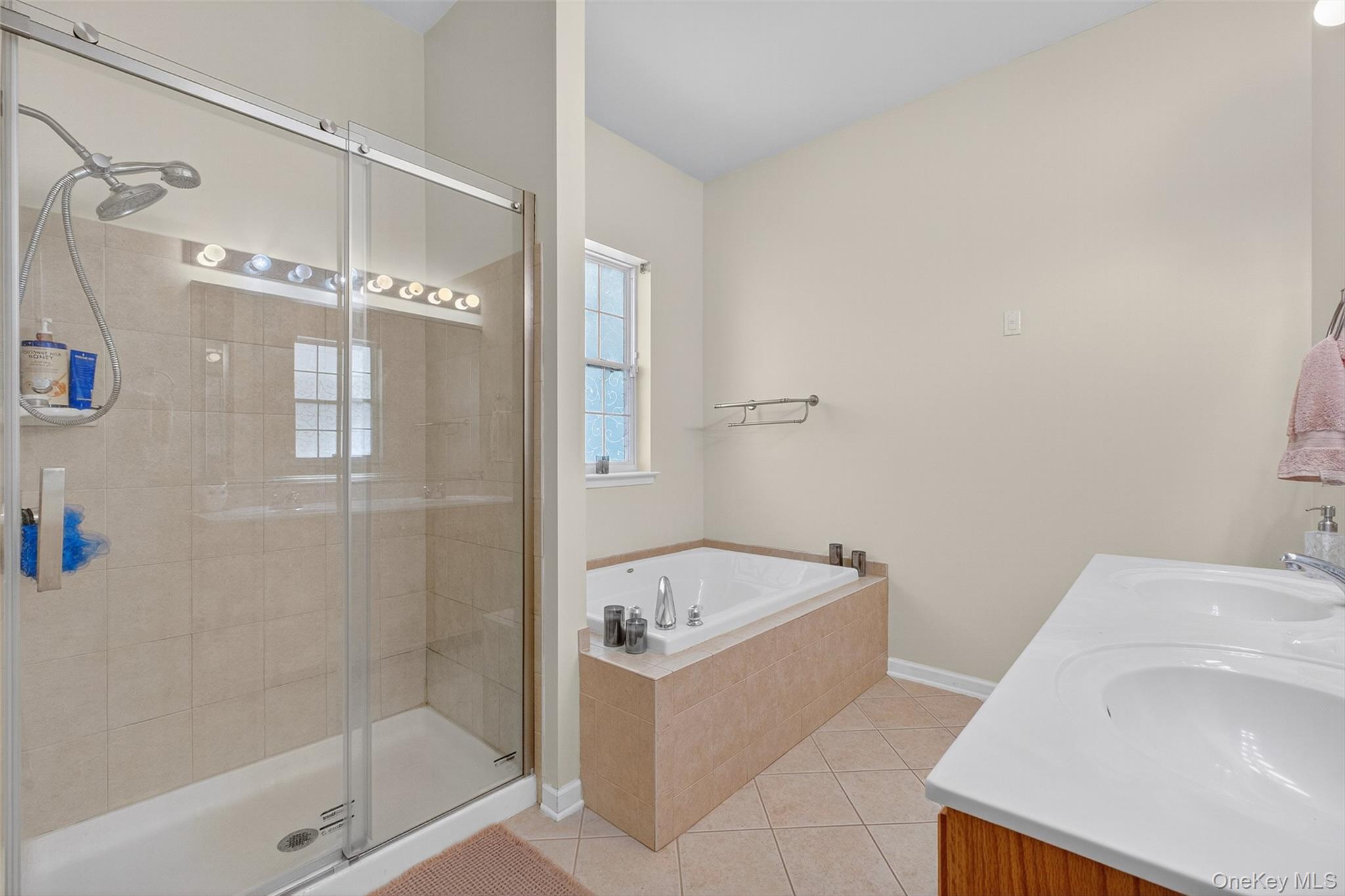 146 Stony Brook Road Fishkill, NY 12524 - Photo 9 of 12 Bathroom featuring light tile patterned floors, a shower stall, double vanity, and a bath