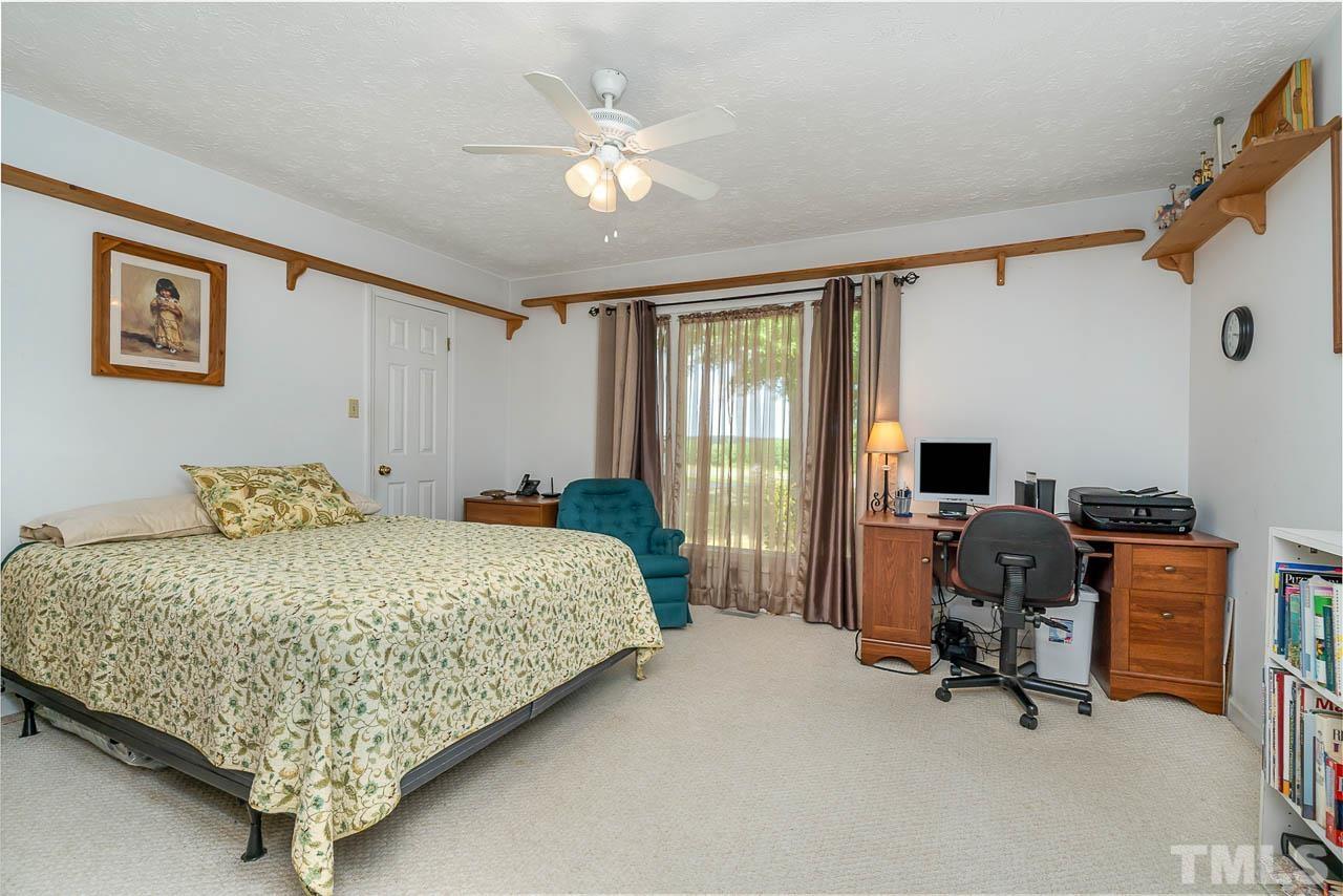 3255 Walters Road Creedmoor, NC 27522 - Photo 12 of 19 a bedroom with a bed and a chandelier