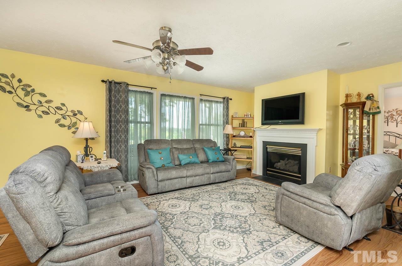 3255 Walters Road Creedmoor, NC 27522 - Photo 4 of 19 a living room with furniture a fireplace and a flat screen tv