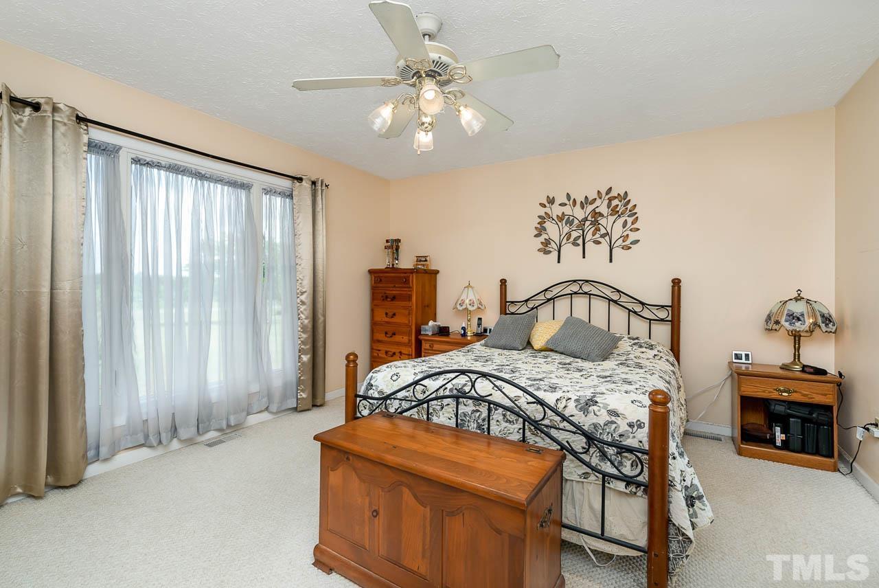 3255 Walters Road Creedmoor, NC 27522 - Photo 9 of 19 a bedroom with a bed a table and chair