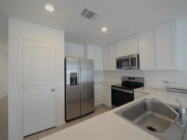 a kitchen with stainless steel appliances granite countertop a refrigerator sink and microwave