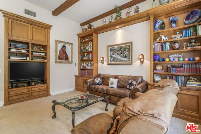 a living room with furniture a flat screen tv and a bookshelf