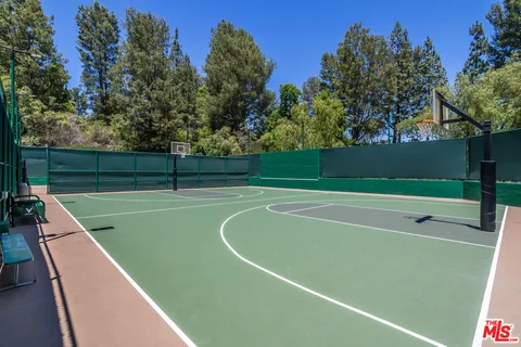a view of a swimming pool with a yard and large trees